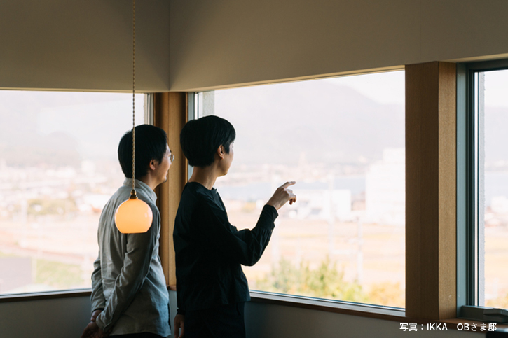 滋賀県湖西の完成見学会の家の窓から景色を眺める夫婦
