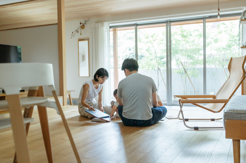 猫と暮らす家の床で寛ぐ家族